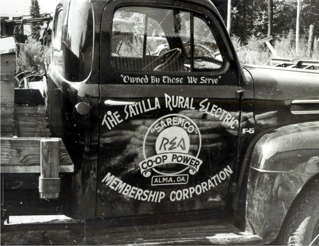A black and white photo of an old Satilla EMC service truck